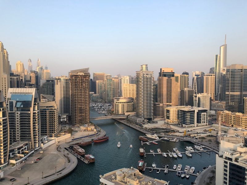 high rise buildings near calm water at daytime