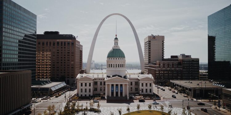 white and green dome cathedral in between high-rise buildings during daytime