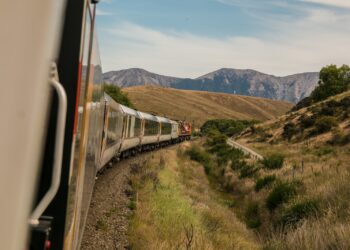 white train with the distance of mountain during daytime
