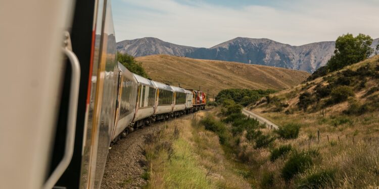 white train with the distance of mountain during daytime