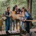 People Standing on a Wooden Bridge while Reading a Map