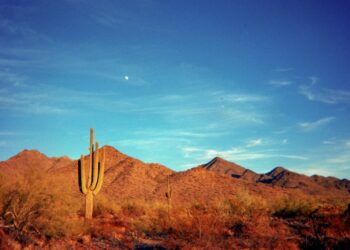 brown and gray house near brown mountain under blue sky during daytime