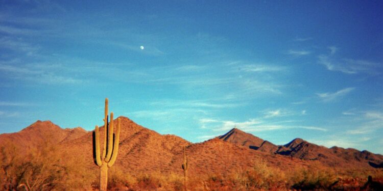brown and gray house near brown mountain under blue sky during daytime