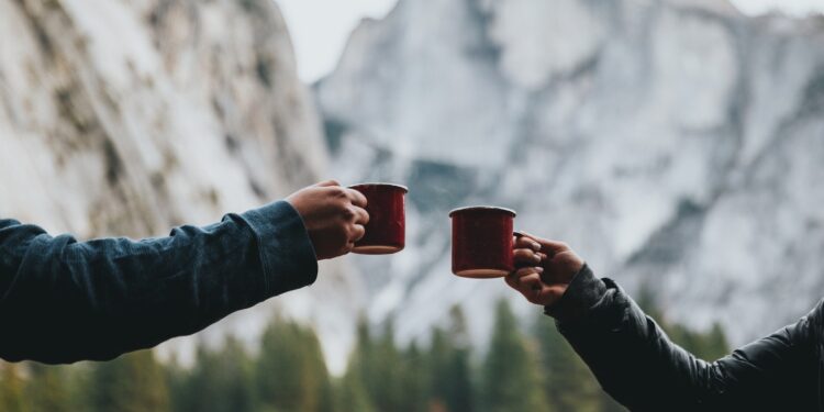 two person holding red mugs