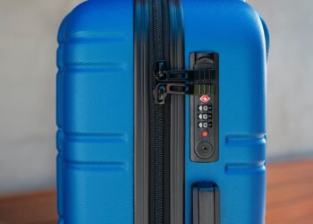 a blue piece of luggage sitting on top of a wooden table