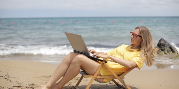 Woman in Yellow Shirt Sitting on Brown Wooden Folding Chair on Beach
