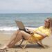 Woman in Yellow Shirt Sitting on Brown Wooden Folding Chair on Beach