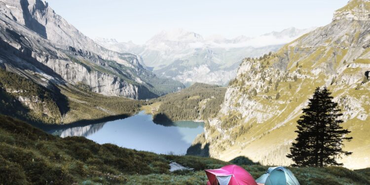 red and gray tents in grass covered mountain