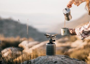 Person Pouring Brown Liquid on White Ceramic Mug