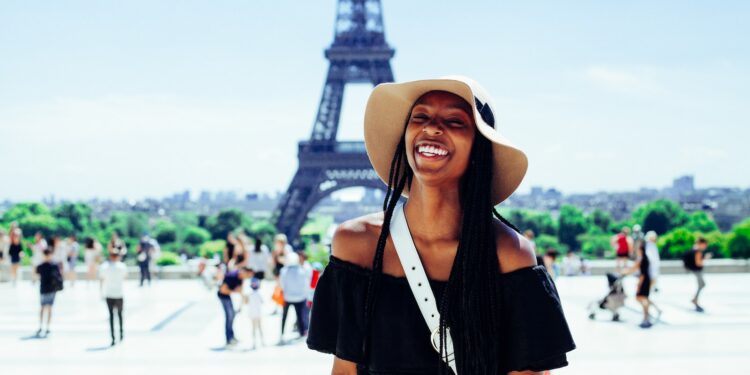 woman standing behind Eiffel Tower during daytime