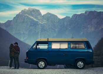 man and woman standing beside blue van