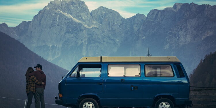 man and woman standing beside blue van