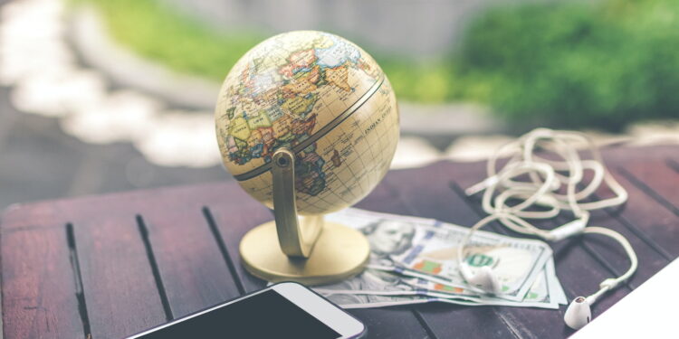 gray desk glove above U.S dollar beside iPhone and white airpods