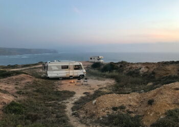 white and brown rv on brown field under blue sky during daytime