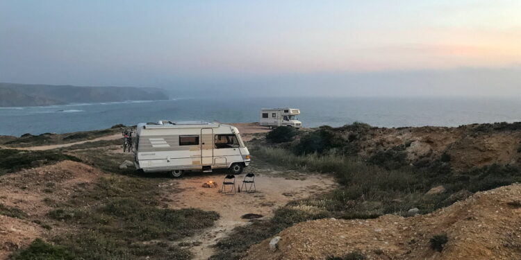 white and brown rv on brown field under blue sky during daytime