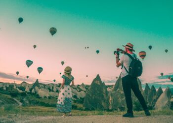man taking photo of hot air balloons