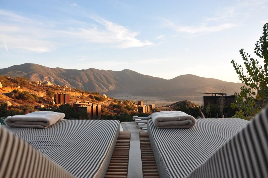 a luxury view with sunloungers fronting buildings near mountain