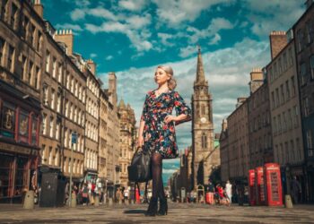 woman in black and red floral dress standing on the street