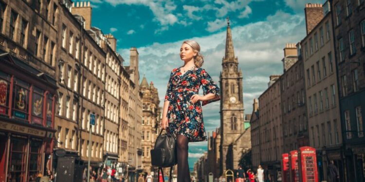 woman in black and red floral dress standing on the street
