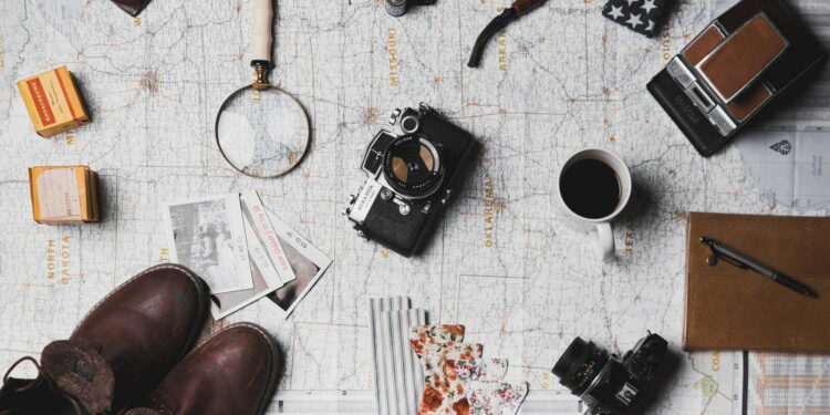camera, pair of brown shoes, white ceramic mug, grey and black pen, brown smoking pipe